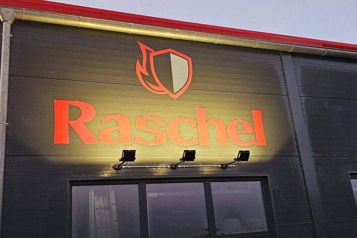 Beleuchtete Fassade eines Gewerbegebäudes in der Abenddämmerung