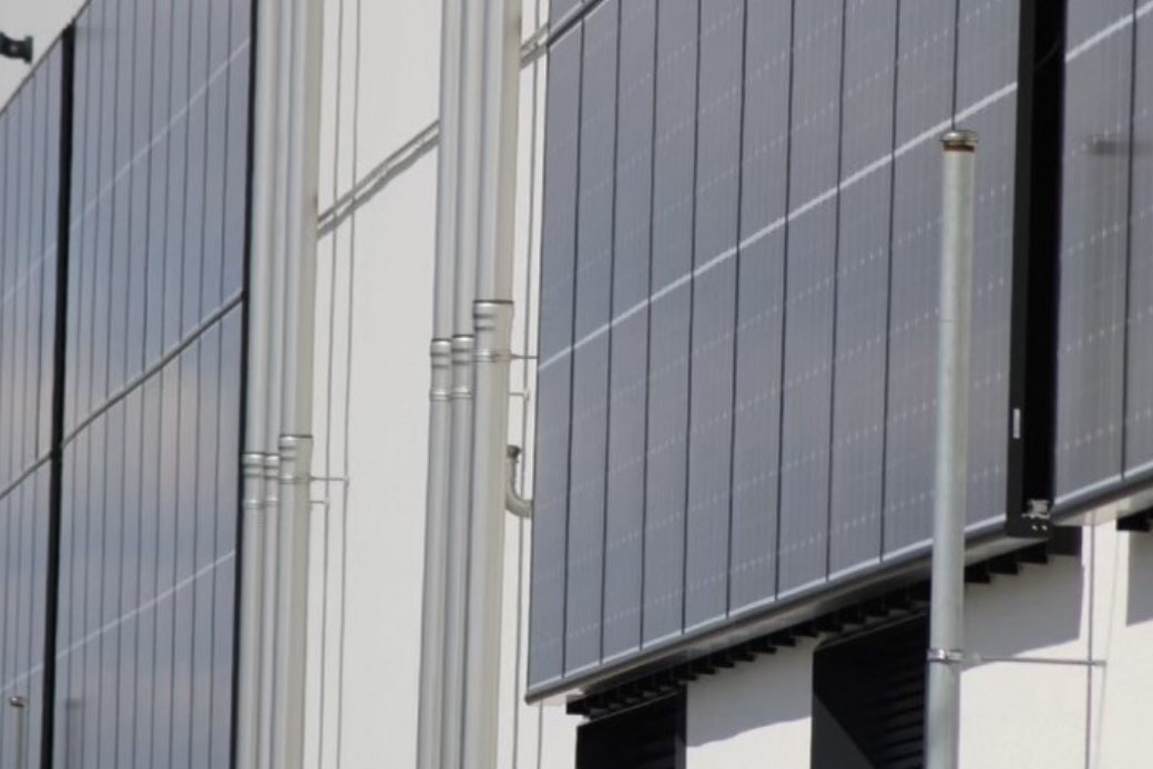 PV-Fassade mit dunklen Modulen an einem Gebäude