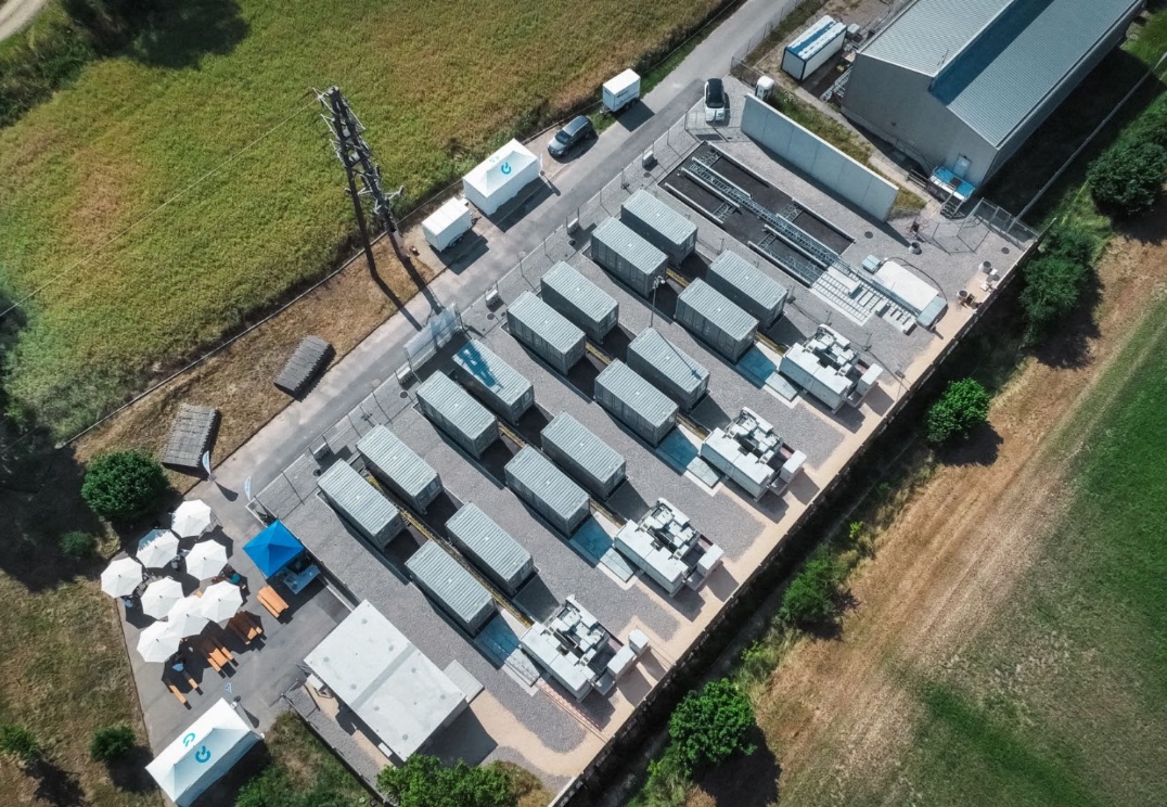 Luftbild eines Batteriespeicherparks mit Speichercontainern und Wechselrichterstationen zwischen Feldern
